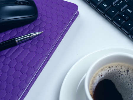 Office table desk. Workspace with note book, keyboard, office supplies and coffee cup on white background.の写真素材