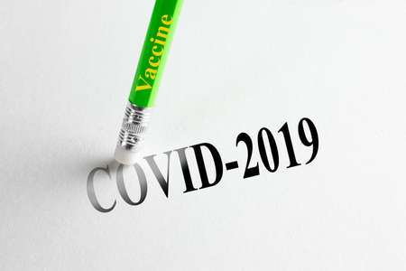 Pencil-eraser with the inscription vaccine trying to remove the word COVID-2019 on paper. The...