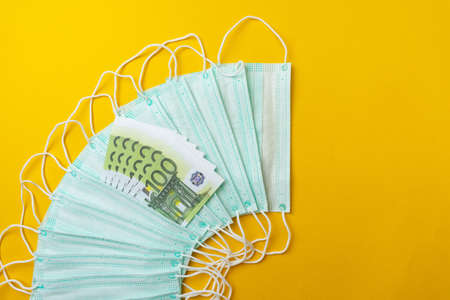 Medical face masks and money. Surgical face mask. COVID-19 has caused a shortage and rise in prices of face masks.の写真素材