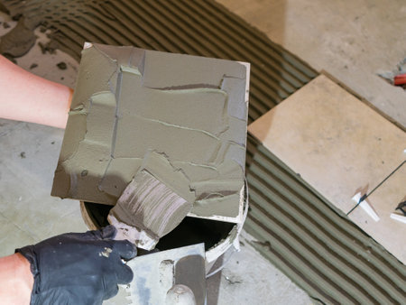 Applying thinset mortar on a tile. Apply the adhesive, closeup.