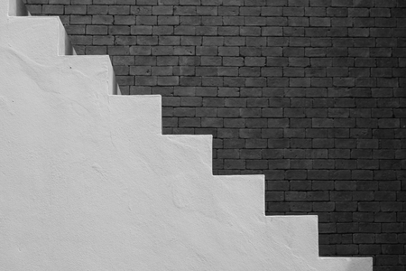 Side view of white empty stairs with brown brick wall background in vintage style. (Black and White filter effect)の写真素材