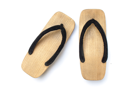 Old wooden Japanese sandal isolated on white background. It is a form of traditional Japanese footwear that resemble both clogs and flip-flops.の写真素材