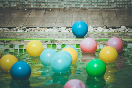 Close up blue small ball on tile floor with many colorful small ball in the pool foreground in vintage style. (Selective focus)の写真素材