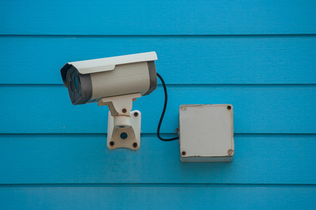 Old Closed Circuit Television Camera or Security CCTV camera setting on  blue wooden background....