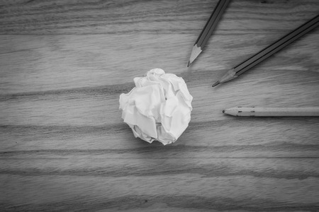 Business Creative and Idea Concept Top view of three pencil with white crumpled paper ball put on wooden floor in black and white image.の写真素材
