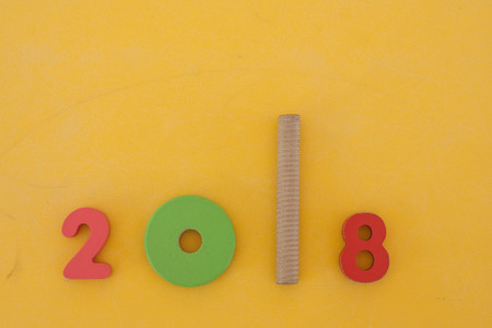 Colorful new year 2018 wording made from kid toys setting on yellow background in vintage style. (Selective focus)の写真素材