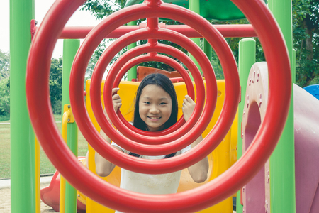 Adorable and Holiday Concept : Cute little child feeling funny and happiness on playground in the park.の写真素材