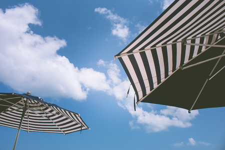 Summer Vacation and Holiday Trip Concept : Close up black and white umbrella beach with blue sky in the background. (Selective focus)の写真素材