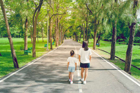 Woman and child walking on footpath and walkway in the public park and feeling happiness and enjoy.の写真素材