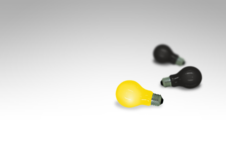 Business Creative and Idea Concept : Yellow light bulb lay on gray floor surrounded with many black light bulb.の写真素材