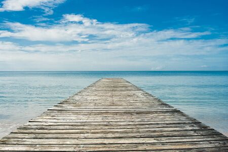 Beautiful seascape tropical view of Wooden bridge bring to the sea with blue sky in summer seasonal.の写真素材