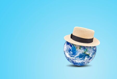 Summer Vacation and Holiday Concept : Blue planet earth globe wear weave hat on blue background.の写真素材