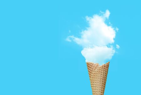 Summer Vacation and Holiday Concept : Ice cream cone with white cloud in blue background.の写真素材