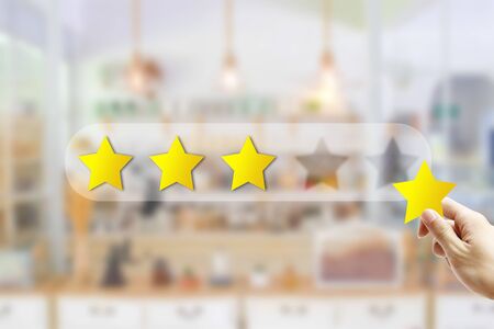 Customer Feedback Concept : Hand holding and giving yellow star for best service ranking with...
