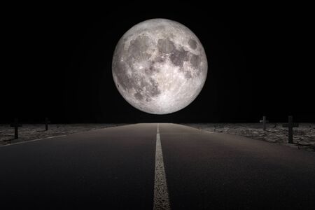 Halloween Concept : Empty road leading to full moon flanked with tomb in dark night. (Elements of this image furnished by NASA.)の写真素材