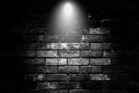 Abstract image of Spot lighting with black brick wall in background.の写真素材
