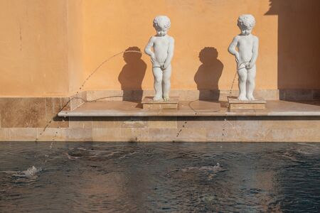 Abstract image of Shabby white statue or sculpture child standing and peeing or urine nearly...