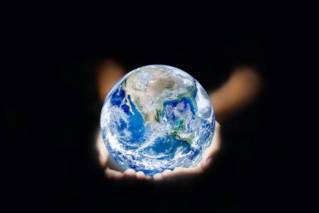 Ecology Concept : Hand holding blue planet earth globe in dark light.