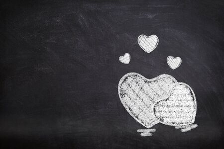 Valentine Concept : Many white hearts chalk symbol on chalkboard.の写真素材