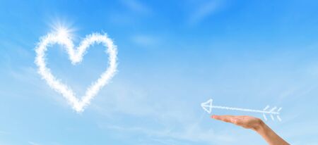 Valentines Day Concept : Female hand holding white arrow and shooting to white heart.