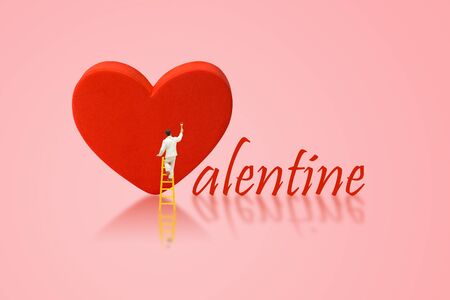 Valentine Concept : Miniature figurine character as painter painting red heart shape.の写真素材