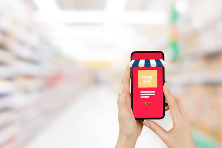 Shopping Online Concept : Hand holding smartphone that showing shopping shop store and shopping cart...