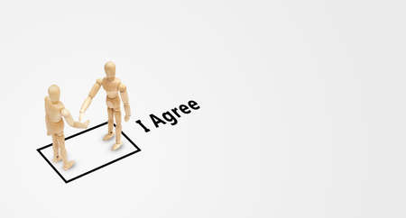 Business Concept : Wooden model toys standing in checkbox of agreement wording and they shaking...