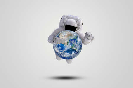 Blue planet earth in hand of Astronaut flying over gray background.の写真素材