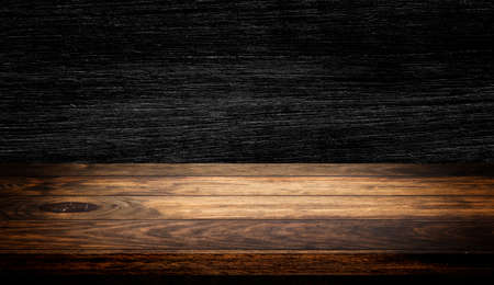 Side view of Empty wooden table top with dark wooden wall texture background for product showing.