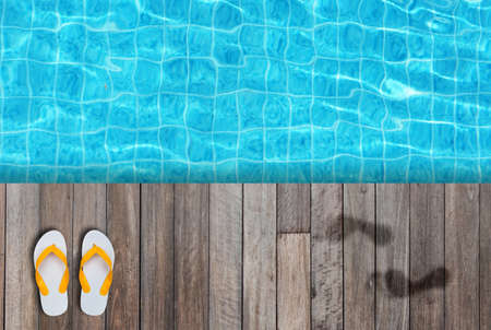 White flip flops, sandals or slippers and wet human footprint on wooden floor or Terrace beside blue...