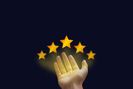 Customer Feedback, Experience and Satisfaction Concept : Hand showing and giving best service ranking with five stars on black background.の写真素材