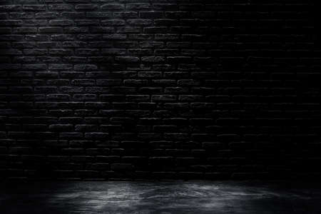 Studio dark room with black brick wall with concrete floor and lighting effect.