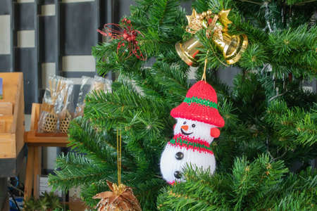 Winter Christmas Background Concept : Snow toy hang on green pine tree.の写真素材