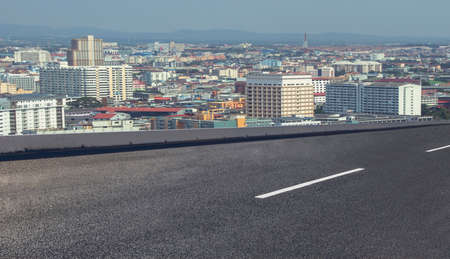 Empty asphalt street road on highway with cityscape in background.の写真素材