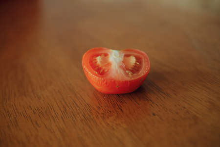 Half slice tomato on top of wooden table