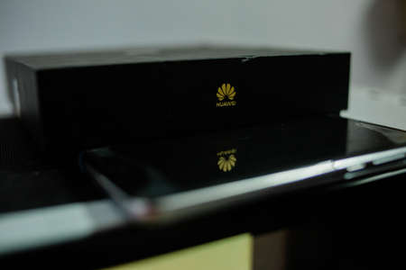 PERAK, MALAYSIA - MAY 24, 2019:The close up photo of Huawei logo on huawei mobile box and reflection of the Huawei logo on the smartphone.のeditorial素材