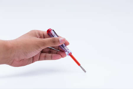 Hand holding voltage test pen screwdriver isolated on white background
