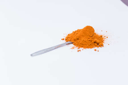 Curry powder in the top of the spoon isolated on white backgroundの写真素材