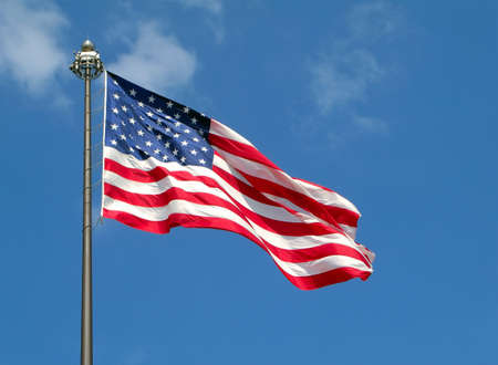 American flag on pole against a blue sky background.