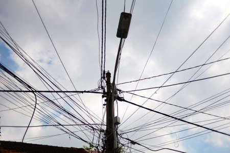 Street light and electrical pole connected with wires in front of sky background. Taken in District 4, Ho Chi Minh city October 2017のeditorial素材