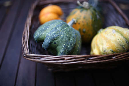 Pumpkins inside wooden basket on a wooden surfaceの写真素材