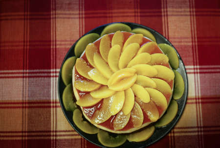 Cake with dark chocolate and peach mousse, and are decorated with slices of peaches on topの写真素材