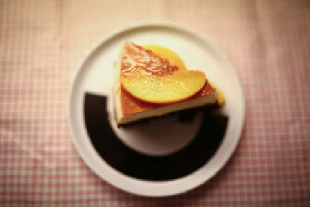 Cake with dark chocolate and peach mousse, and are decorated with slices of peaches on topの写真素材