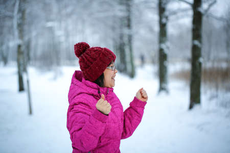 Young and happy asian girl with a pink jacket enjoys snowingの写真素材