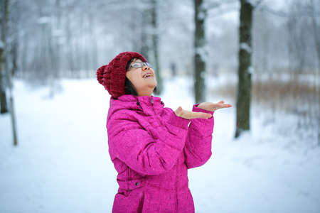 Young and happy asian girl with a pink jacket enjoys snowingの写真素材
