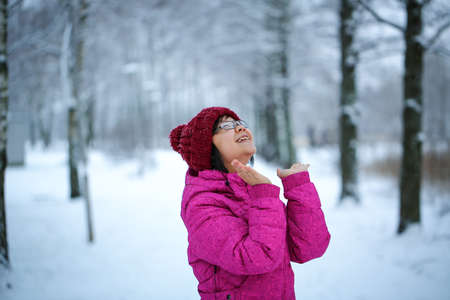 Young and happy asian girl with a pink jacket enjoys snowingの写真素材