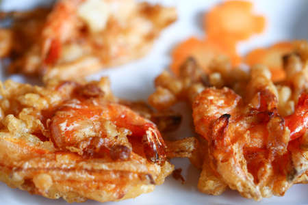 Vietnamese traditional food: fried shrimp and sweet potato fritters are served with carrot slices on...
