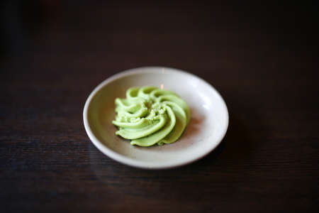 Wasabi paste on a tiny dish on a wooden backgroundの写真素材