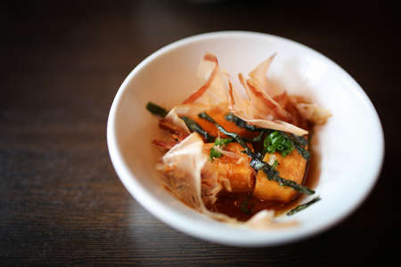 Japanese foods include sushi, nigiri, sashimi, served on small plate on a wooden backgroundの写真素材