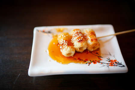 Japanese foods include sushi, nigiri, sashimi, served on small plate on a wooden backgroundの写真素材